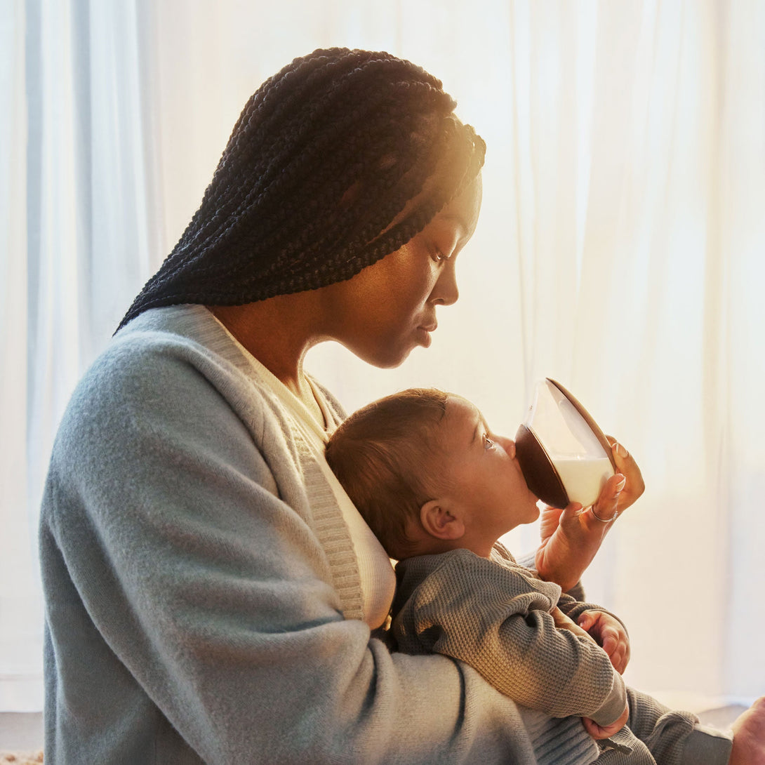 Mother holding baby with Emulait Anatomy bottle