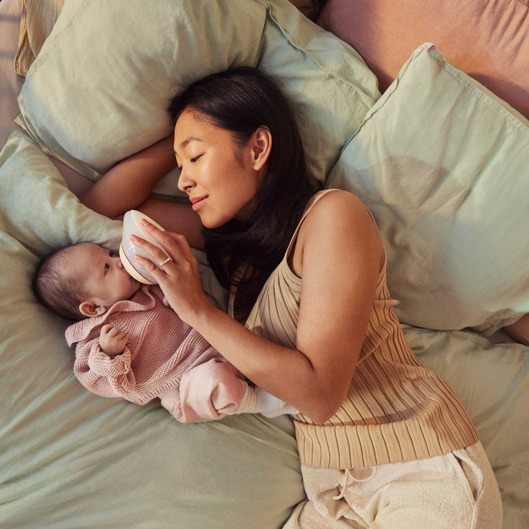 Mother and Baby Lying Down, Little One Drinking Milk from Emulait Anatomy Bottle