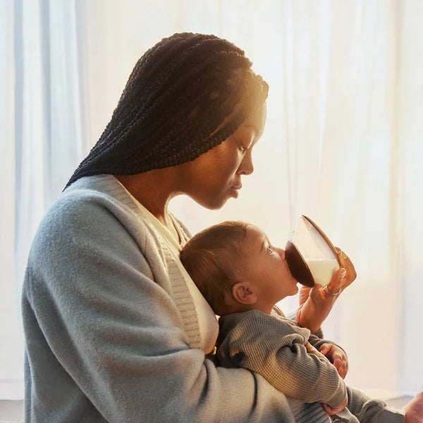 Mother feeding baby with Emulait Anatomy bottle