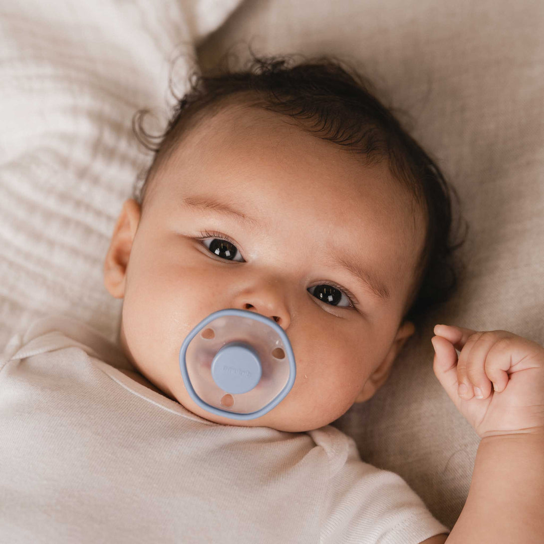 Baby lying with Blu Emulait Pacifier