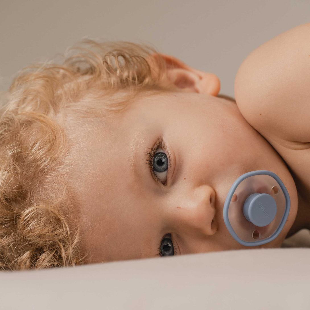 Baby lying with Blu Emulait Pacifier